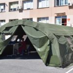 Zielony namiot wojskowy z pracownikiem w środku