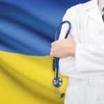 lekarz ze stetoskopem na tle flagi Ukrainy niebiesko żółtej