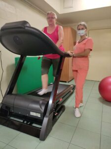 pacjentka podczas ćwiczeń na bieżni w towarzystwie fizjoterapeuty - dr Szymury