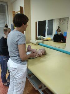 fizjoterapeutka Bernadetta Palińska-Biel z niemowlakiem w czasie ćwiczeń