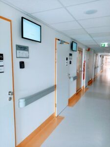 korytarz po remoncie w POZ z ekranami obok drzwi do gabinetów lekarskich