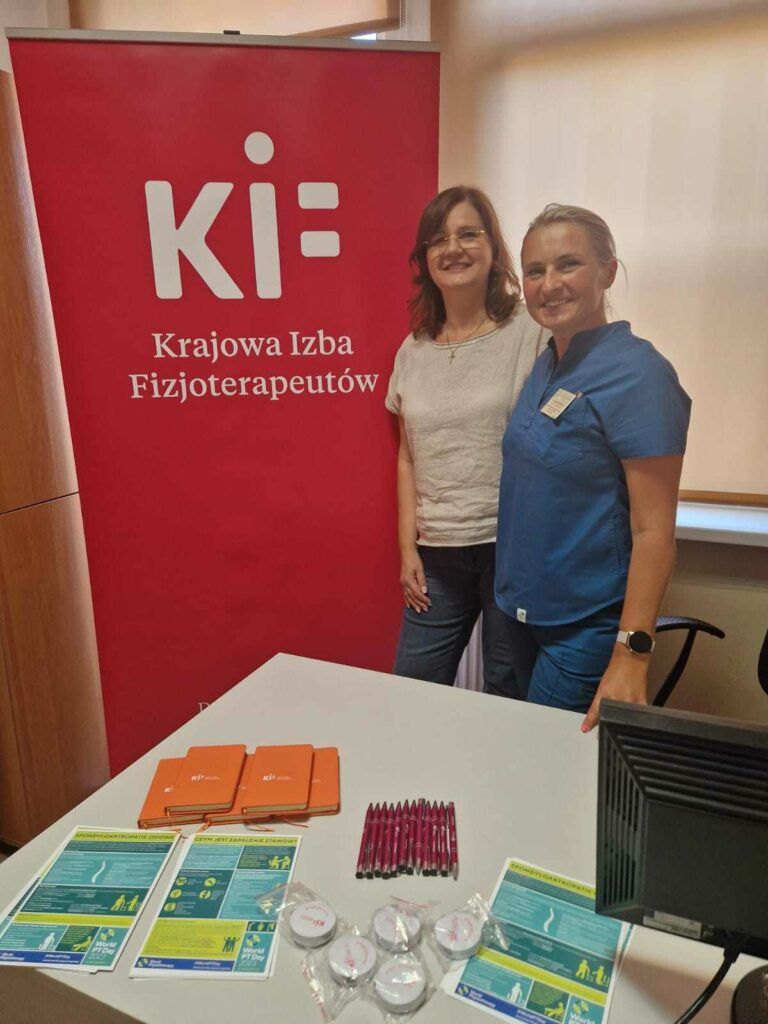 przedstawicielka KIF i fizjoterapeutka na tle baneru KIF z upominkami dla pacjentów